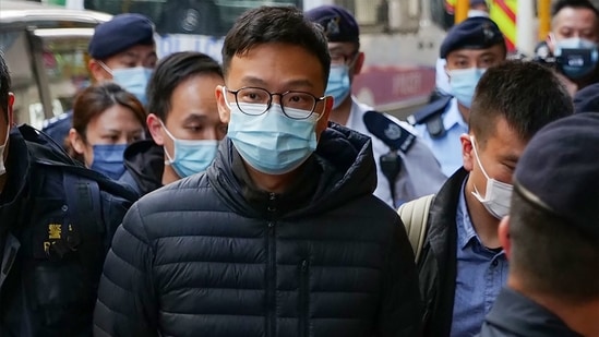 Stand News chief editor Patrick Lam is brought to the news outlet's office building in handcuffs after police were deployed to search the premises in Hong Kong's Kwun Tong district.(AFP Photo)