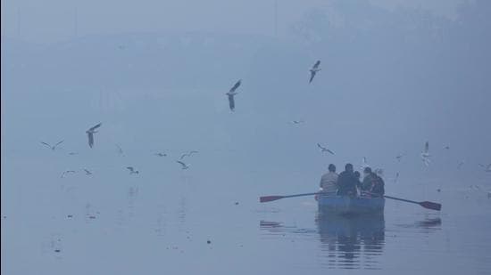 Visitors are seen on a boat amid dense fog near Yamuna Bazaar in New Delhi last weekend. (Sanchit Khanna/ HT)