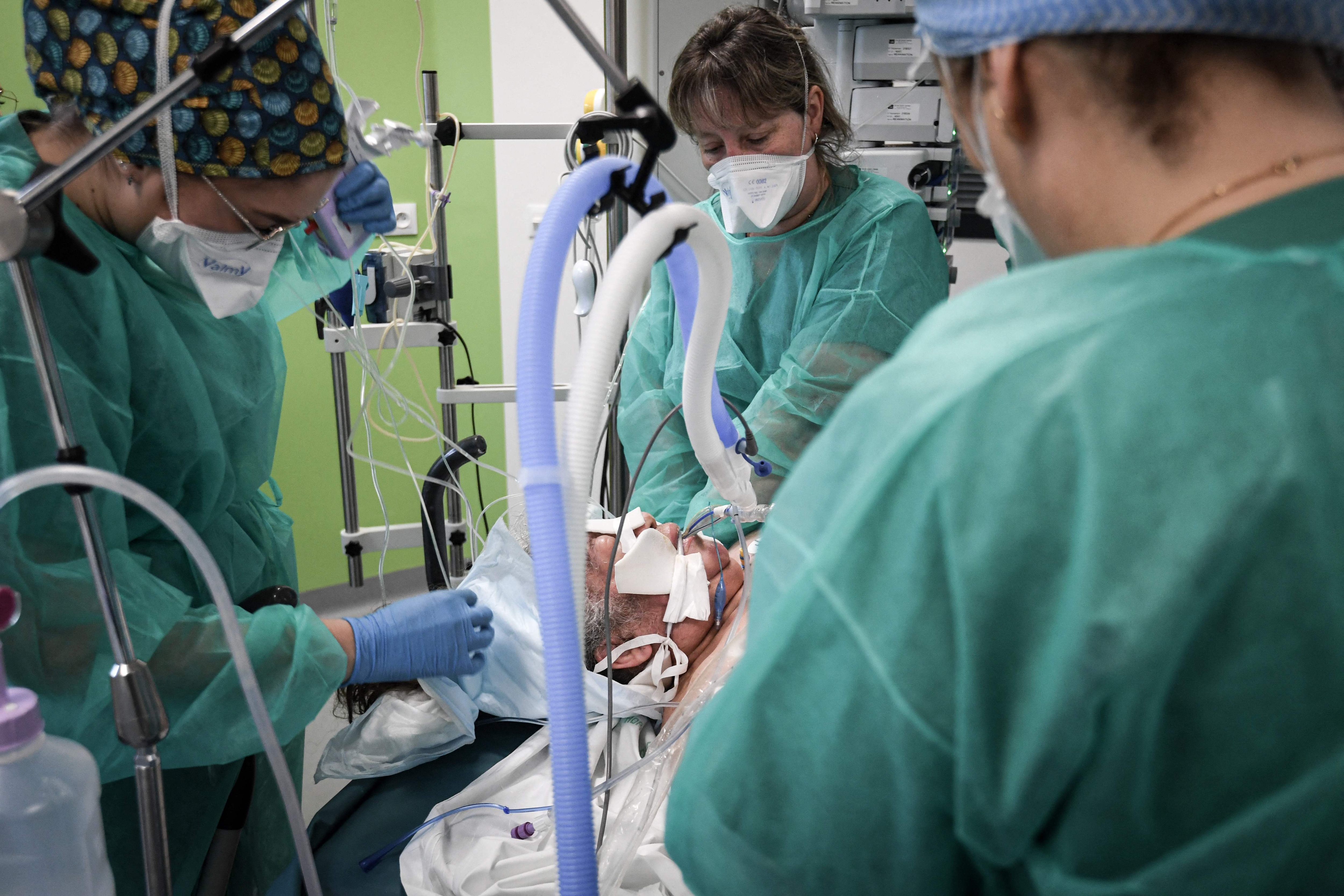 Nurses tend to a Covid-19 patient at a hospital outside Paris. (AFP) Nurses tend to a Covid-19 patient at a hospital outside Paris. (AFP)