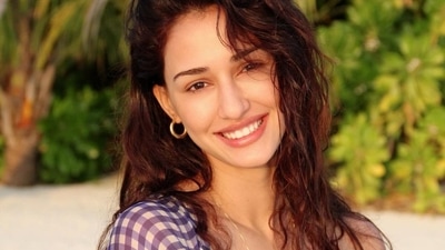 The pink bikini top was layered with a sheer blue and white chequered shrug that came with full sleeves and drooping shoulders and was worn unbuttoned. (Instagram/dishapatani) The pink bikini top was layered with a sheer blue and white chequered shrug that came with full sleeves and drooping shoulders and was worn unbuttoned. (Instagram/dishapatani)