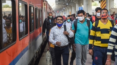 Passengers wearing face masks as a precaution against coronavirus arrive at Dadar railway station in Mumbai, Thursday. (PTI)
