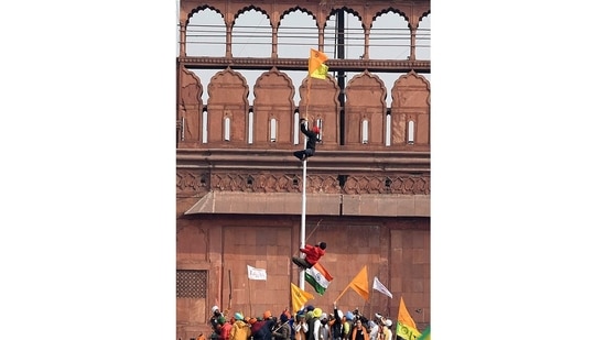 Nishan Sahib being hoisted near the Indian tricolour at Red Fort in New Delhi, on January 26. On&nbsp;Republic Day, thousands of farmers protesting against the three farm laws (now repelled) drove a convoy of tractors into the capital. The tractor rally took an unsavoury turn that ended in violence, with one group storming the Red Fort in Delhi.&nbsp;(Sanjeev Verma / HT Photo)