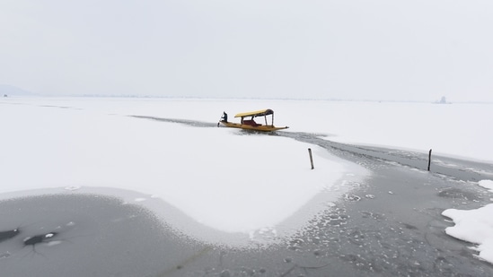 A boatman uses an oar to break a sheet of ice on Dal Lake in Srinagar on January 9.(Waseem Andrabi / HT Photo)