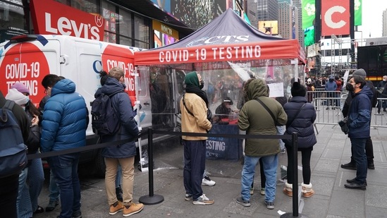 People stand in line for a Covid-19 test at a mobile testing site in Times Square in New York.(AFP)