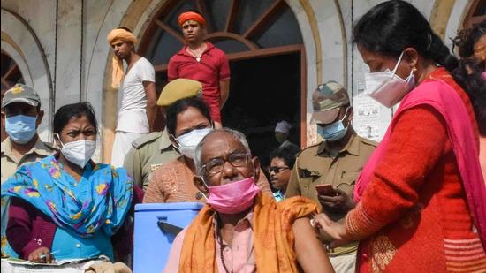 A health worker administers a dose of Covid-19 vaccine to a pilgrim in front of the Kapil Muni temple, ahead of the upcoming Gangasagar Mela, at Gangasagar in South 24 Parganas district, West Bengal, on Thursday. (PTI)