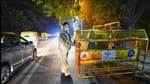 A Delhi Police personnel puts in place barricades at the entrance of Hauz Khas village in New Delhi on New Year’s eve on Friday. (Amal K S/HT photo)