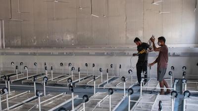 Workers prepare new Covid center amid the rising cases of Omicron in Mumbai. (Pratik Chorge/HT Photo) Workers prepare new Covid center amid the rising cases of Omicron in Mumbai. (Pratik Chorge/HT Photo)