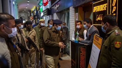 A Delhi Police officer speaks to a restaurant manager while patrolling Connaught Place on 31st night.&nbsp; (AP)