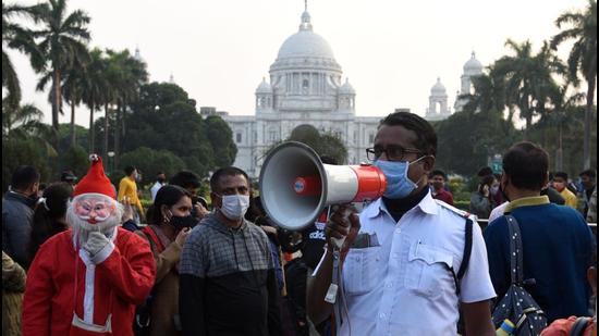 Kolkata Police personnel make a public announcement amid the rise of Covid-19 cases as people throng to the iconic Victoria Memorial Hall on the last day of 2021 in Kolkata on Friday. (HT PHOTO.) Kolkata Police personnel make a public announcement amid the rise of Covid-19 cases as people throng to the iconic Victoria Memorial Hall on the last day of 2021 in Kolkata on Friday. (HT PHOTO.)