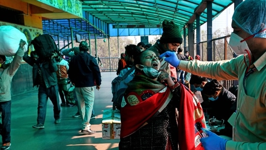 A healthcare worker collects a swab sample of a passenger for the Covid-19 testing at New Delhi Railway Station.&nbsp;