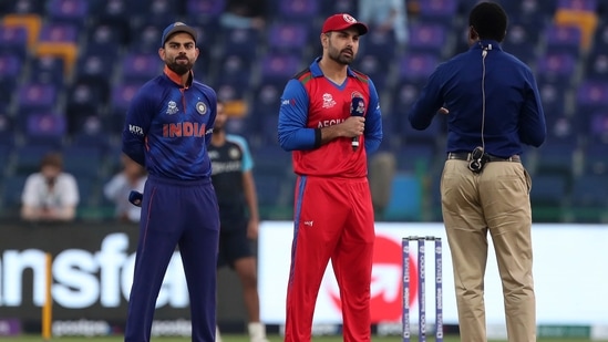 Afghanistan's captain Mohammad Nabi, center, listens to a question from the commentator after winning the toss as India's captain Virat Kohli, left, looks on during the Cricket Twenty20 World Cup match between India and Afghanistan in Abu Dhabi, UAE, Wednesday, Nov. 3, 2021. (AP Photo/Aijaz Rahi)(AP)