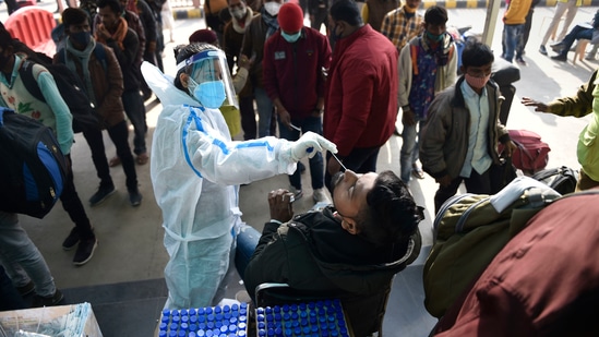 A health worker collects swab samples of passengers to conduct a Covid-19 test at the Anand Vihar railway station near New Delhi.(PTI)