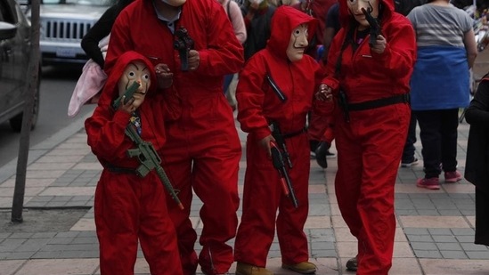 A family dressed as characters from the serie "La Casa del Papel" (Money Heist) collect candies during the Halloween celebration amid the Covid-19 pandemic in La Paz, Bolivia, Saturday, October 31, 2020. (AP Photo/Juan Karita)