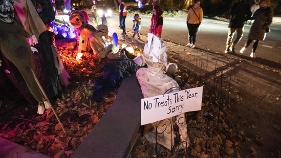A sign outside a home decorated for Halloween reads "No treats this year, sorry" as residents decline participating in trick-or-treating due to the Covid-19 pandemic in Ottawa, Ontario, Saturday, October 31, 2020. (AP Photo/Justin Tang)