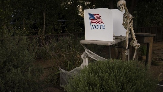 A skeleton stands next to a mock polling booth as part of Halloween decoration in Pasadena, Calif., Saturday, October 31, 2020, as in-person voting started for most California counties this weekend. (AP Photo/Jae C. Hong)