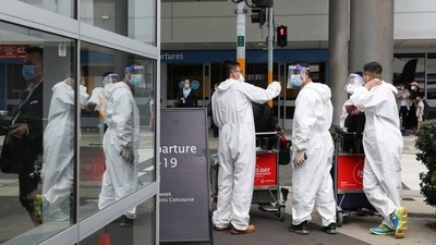 Travellers wear personal protective equipment outside the international terminal at Sydney Airport. (Reuters File Photo)