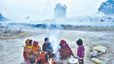 A family sits near a small fire to warm themselves on a cold winter morning, in New Delhi on Sunday. The IMD has predicted rainfal across northwest and central India this week. (PTI) A family sits near a small fire to warm themselves on a cold winter morning, in New Delhi on Sunday. The IMD has predicted rainfal across northwest and central India this week. (PTI)