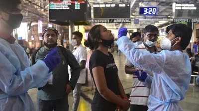 A health worker collects the swab sample of a passenger for Covid-19 test at CSMT in Mumbai on Saturday. (Anshuman Poyrekar/HT Photo) ( (Anshuman Poyrekar/HT Photo))