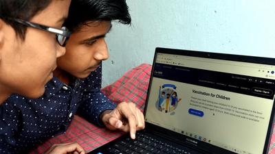 Two boys book slots for Covid-19 vaccination in New Delhi on Sunday. (Arvind Yadav/HT photo)