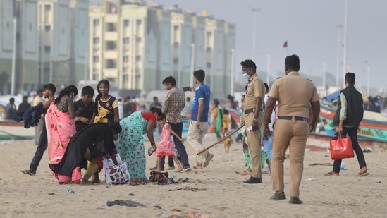 Policemen ask people not to sit on the Marina beach as Greater Chennai Corporation has allowed visitors to the beach for walking purposes only,&nbsp;(PTI)