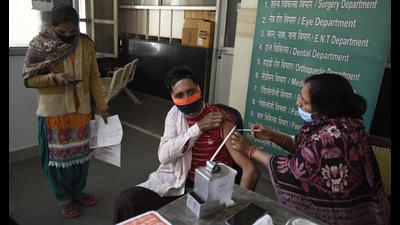 A health worker administers a dose of Covid-19 vaccine to a beneficiary at a polyclinic in Gurugram’s Sector 31. (Parveen Kumar/HT)