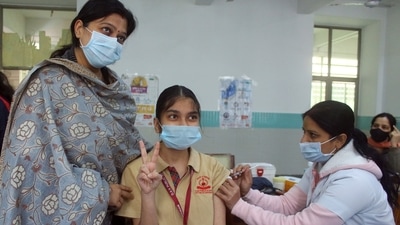  A girl shows victory sign while receiving her first dose of Bharat Biotech's Covaxin against the COVID-19 virus during a vaccination drive for children aged 15-18 years, at DAV Public School, in Gurugram. (ANI) A girl shows victory sign while receiving her first dose of Bharat Biotech's Covaxin against the COVID-19 virus during a vaccination drive for children aged 15-18 years, at DAV Public School, in Gurugram. (ANI)