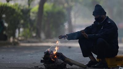 A man tries to keep himself warm near a fire along an alley in New Delhi. (AFP) A man tries to keep himself warm near a fire along an alley in New Delhi. (AFP)