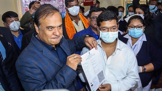 Assam Chief Minister Himanta Biswa Sarma presents a certificate to a teenager on receiving the first dose of the Covid-19 vaccine, in Dibrugarh on January 3. (PTI)