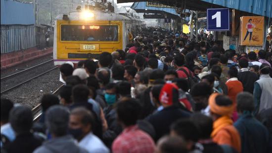 Commuters violate social distancing norms while waiting to board a train at Bidhannagar Station in Kolkata on Monday. (Samir Jana/HT Photo)