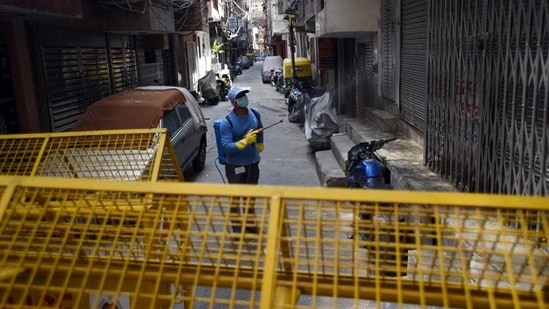 Government officers and staff residing inside Covid-19 containment zones have also been asked to not come to office until their location has been de-notified. In picture - A civic worker spraying disinfectant inside a containment zone.(HT Photo | Representational image)