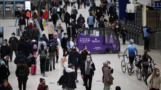 People wearing protective face masks walk through Waterloo train station, amid the Covid-19 outbreak, in London, Britain.(Reuters)