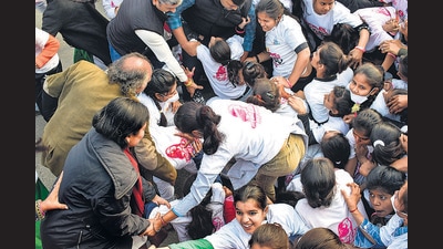 Officials help girls who fell down during a stampede-like situation at Congress's 'Ladki Hoon Lad Sakti Hoon' marathon in Bareilly on Tuesday. (PTI)
