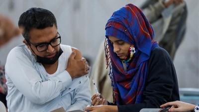 A healthcare worker checks a record card of a man before administering a dose of coronavirus disease (Covid-19) vaccine at a vaccination centre in Karachi, Pakistan. REUTERS/Akhtar Soomro (REUTERS)