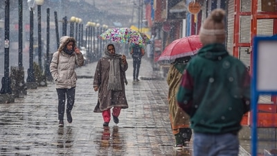 People in warm clothes, step outside during the season's first snowfall in Srinagar. (PTI)