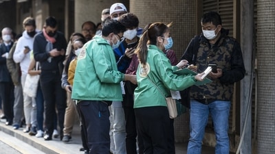 People wait in line outside a community vaccination centre administering the BioNTech Covid-19 vaccine in Hong Kong, on Tuesday. (Bloomberg Photo) People wait in line outside a community vaccination centre administering the BioNTech Covid-19 vaccine in Hong Kong, on Tuesday. (Bloomberg Photo)