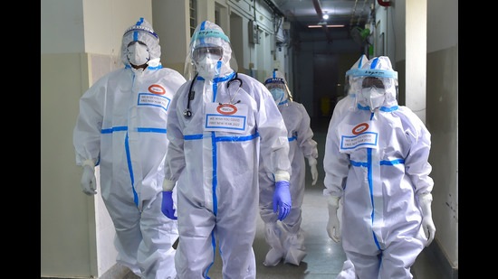 Placards with a message " We wish you Covid free New Year 2022" is seen on the chest of medical staff wearing PPE, inside MS Ramaiah hospital in Bengaluru on December 31, 2021. (PTI)