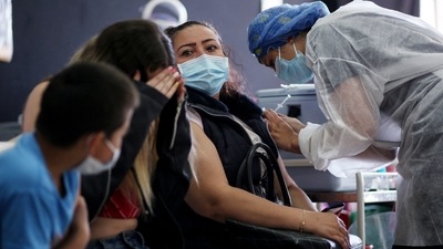 A healthcare worker inoculates a woman with a Covid-19 vaccine at a vaccination centre in Bogota, on Tuesday. (AFP Photo) A healthcare worker inoculates a woman with a Covid-19 vaccine at a vaccination centre in Bogota, on Tuesday. (AFP Photo)