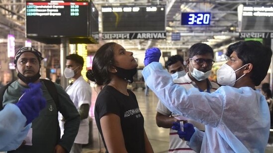A health worker collects the swab sample of a passenger for Covid-19 test at CSMT in Mumbai. (Anshuman Poyrekar/HT Photo)