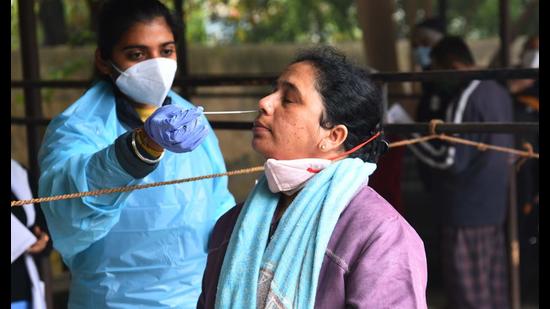 A health worker collects a swab sample for Covid-19 test at a UPHC in Sector 31, Gurugram, on Wednesday. (Vipin Kumar/HT PHOTO)