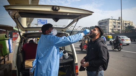 A healthcare worker takes the swab samples from commuters to check for Covid-19 infection, at Punjabi Bagh in New Delhi on Tuesday.(Sanchit Khanna/HT Photo)