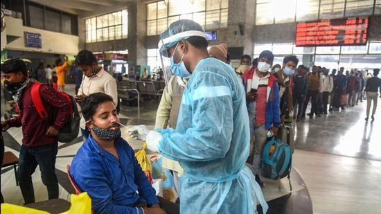 A healthcare worker collects a swab sample of a passenger for Covid-19 test, at Bandra Terminus, in Mumbai on Wednesday. (PTI)