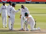 South Africa's Dean Elgar reacts after being hit by the ball on the helmet grill off the bowling of India's Jasprit Bumrah as Virat Kohli checks he is ok