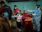 A healthcare worker collects a swab sample from a woman to test for Covic-19, at a railway station in New Delhi.