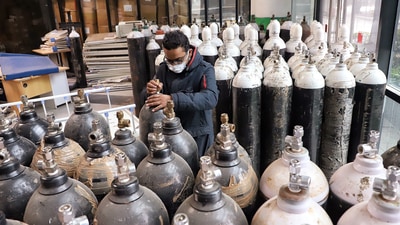 A staff checks the oxygen cylinders at a Covid care centre amid a surge in Omicron cases, at Commonwealth Games Village in New Delhi on Tuesday. (ANI Photo) A staff checks the oxygen cylinders at a Covid care centre amid a surge in Omicron cases, at Commonwealth Games Village in New Delhi on Tuesday. (ANI Photo)