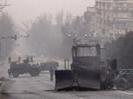 Servicemen and their military vehicles block a street in central Almaty.(AFP)