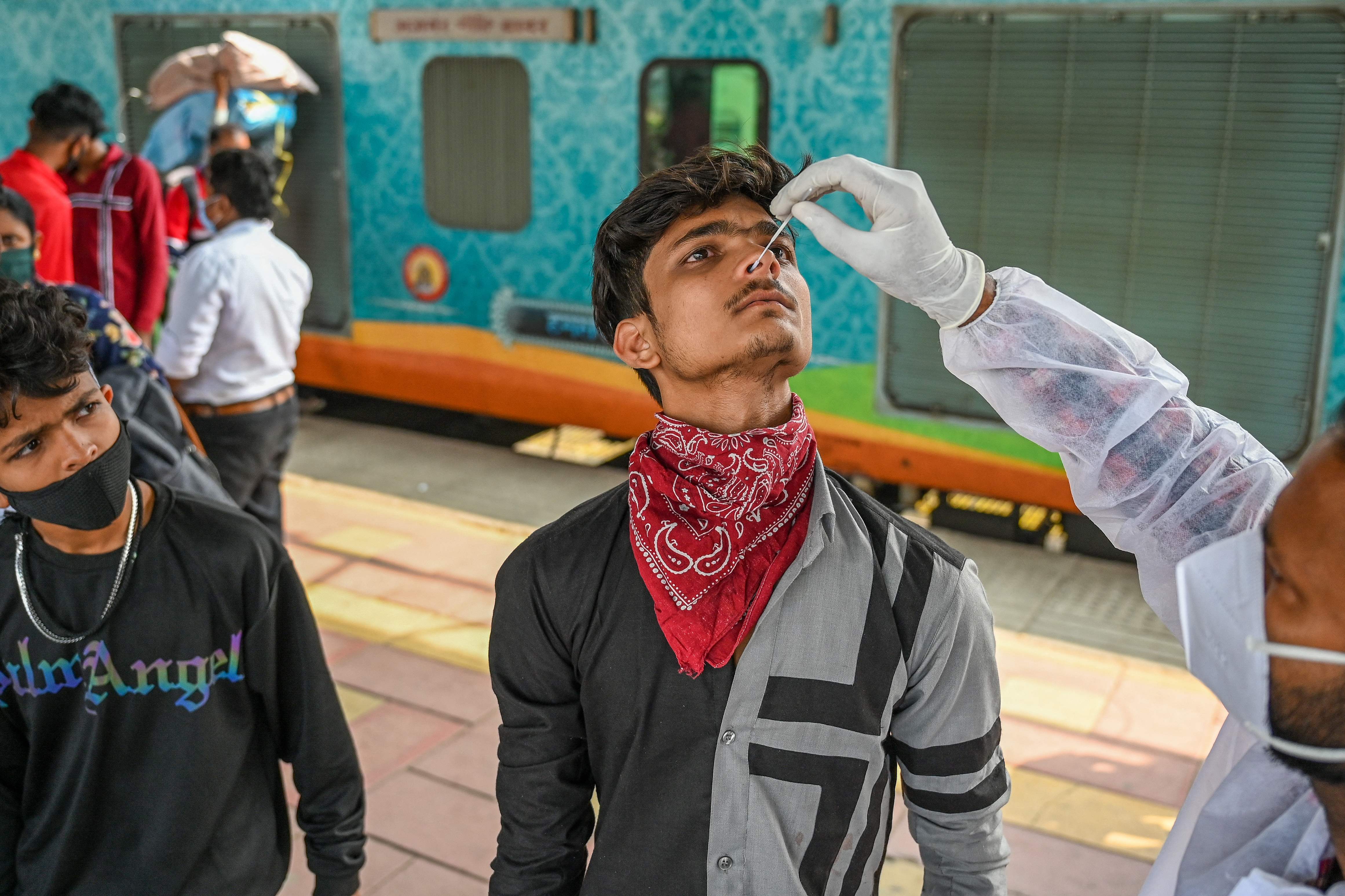 A health worker takes a nasal swab sample of a passenger during a Covid-19 coronavirus screening at a railway platform in Mumbai. (AFP) A health worker takes a nasal swab sample of a passenger during a Covid-19 coronavirus screening at a railway platform in Mumbai. (AFP)