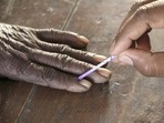 A voting official marks the finger of a voter inside a polling booth. (For representation purpose)(Reuters) A voting official marks the finger of a voter inside a polling booth. (For representation purpose)(Reuters)