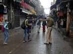 A policeman directs pedestrians to return home during weekend curfew imposed to curb the spread of the coronavirus in New Delhi.(AP) A policeman directs pedestrians to return home during weekend curfew imposed to curb the spread of the coronavirus in New Delhi.(AP)