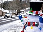 Snow accumulates on the hat of a friendly snowman as he greets motorists along Northeast 159th Street in Hockinson, Wash