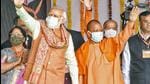 Prime Minister Narendra Modi and Uttar Pradesh chief minister Yogi Adityanath wave to their supporters during the foundation stone laying ceremony of Major Dhyan Chand Sports University, in Meerut. (ANI)